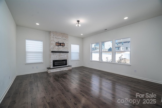 unfurnished living room featuring a fireplace and dark wood-type flooring