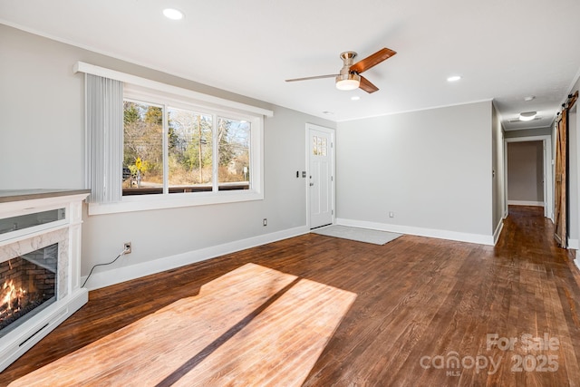 unfurnished living room with ceiling fan and dark hardwood / wood-style flooring