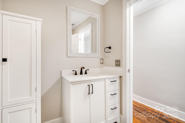 bathroom with wood-type flooring, vanity, and crown molding