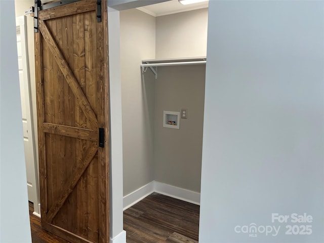 laundry room with hookup for a washing machine, dark hardwood / wood-style floors, crown molding, and a barn door