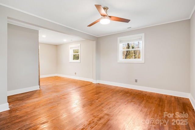 unfurnished room featuring ceiling fan, a wealth of natural light, ornamental molding, and light wood-type flooring