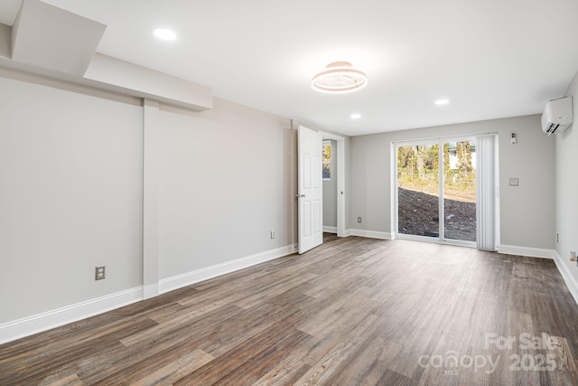 spare room with an AC wall unit and hardwood / wood-style flooring