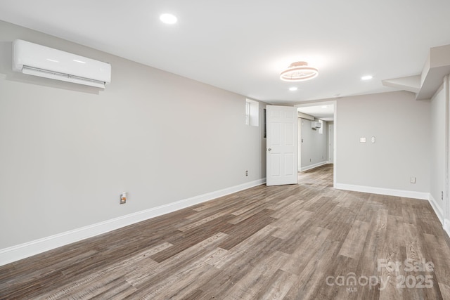 basement featuring a wall mounted AC and hardwood / wood-style floors