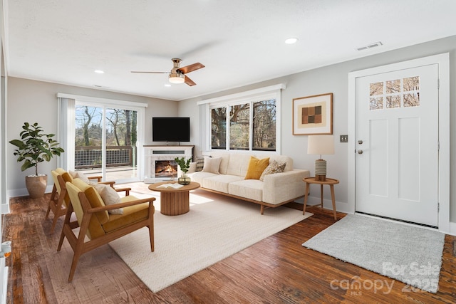 living room with ceiling fan and dark wood-type flooring