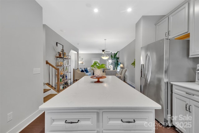 kitchen with stainless steel refrigerator with ice dispenser and a kitchen island