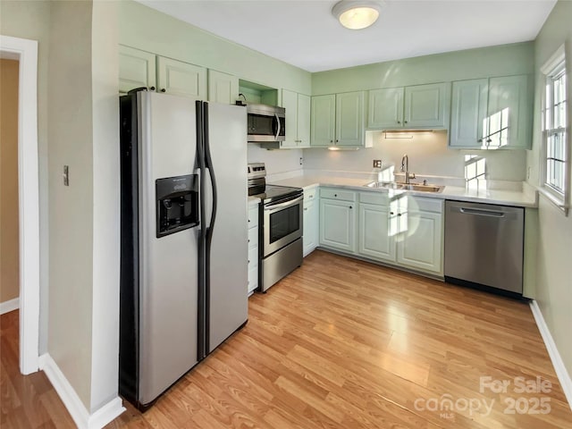 kitchen featuring stainless steel appliances, light hardwood / wood-style flooring, and sink