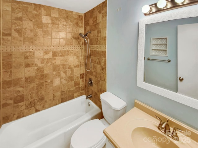 full bathroom with vanity, tiled shower / bath combo, and toilet