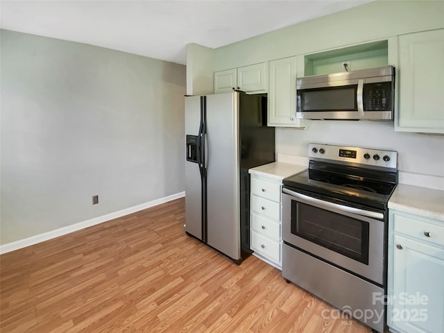 kitchen with appliances with stainless steel finishes, light wood-type flooring, and white cabinetry