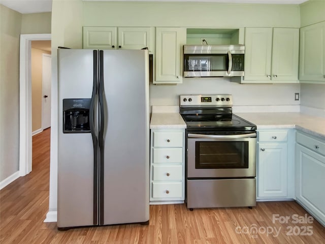 kitchen with white cabinets, stainless steel appliances, and light hardwood / wood-style flooring