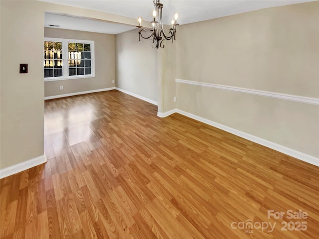 unfurnished dining area with hardwood / wood-style floors and a chandelier