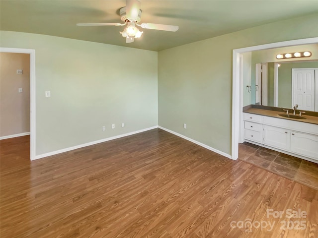 unfurnished bedroom with wood-type flooring, ceiling fan, and sink