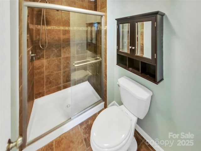 bathroom featuring toilet and an enclosed shower