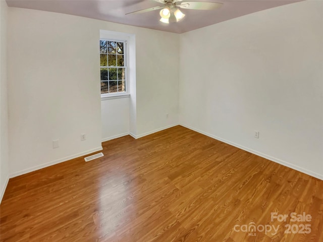 spare room featuring wood-type flooring and ceiling fan