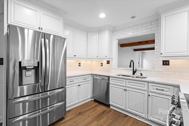 kitchen with white cabinets, appliances with stainless steel finishes, sink, and backsplash