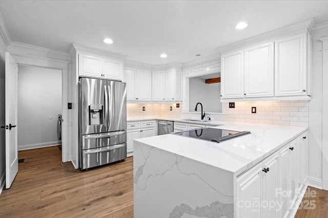 kitchen featuring sink, stainless steel appliances, white cabinetry, and light stone countertops