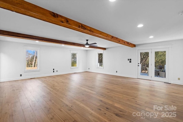 unfurnished living room featuring beam ceiling, ceiling fan, and light wood-type flooring