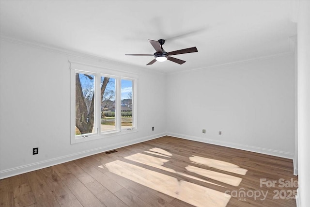 empty room featuring crown molding, wood-type flooring, and ceiling fan