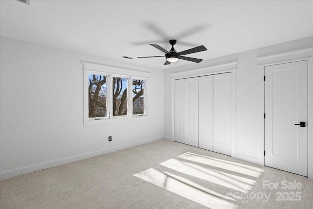 unfurnished bedroom featuring light carpet, a closet, and ceiling fan