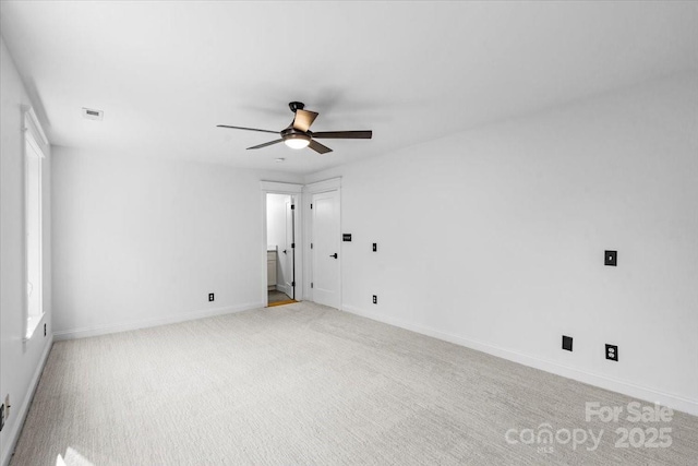 spare room featuring light carpet and ceiling fan