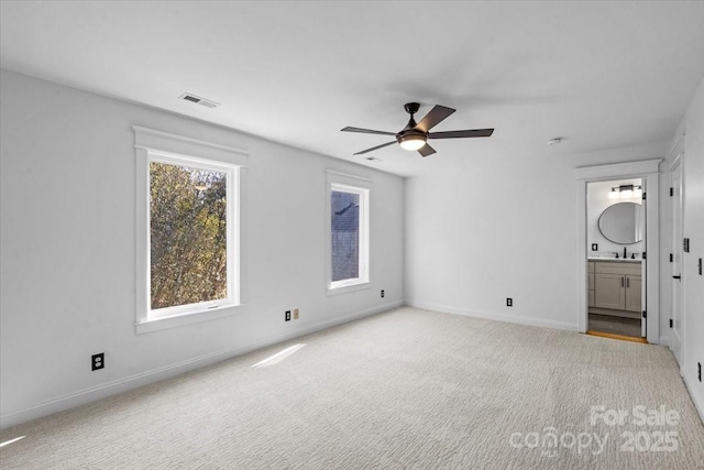 unfurnished bedroom with ceiling fan, sink, ensuite bath, and light carpet