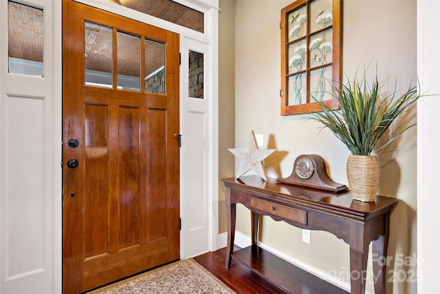 foyer entrance with wood finished floors and baseboards