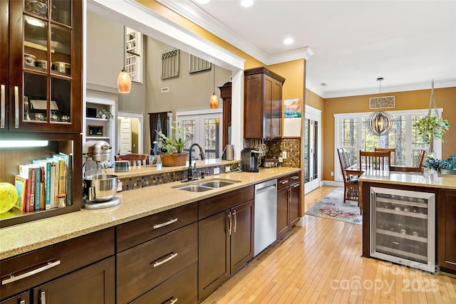 kitchen with wine cooler, glass insert cabinets, a sink, pendant lighting, and stainless steel dishwasher