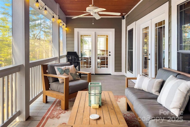 sunroom featuring a ceiling fan and wooden ceiling