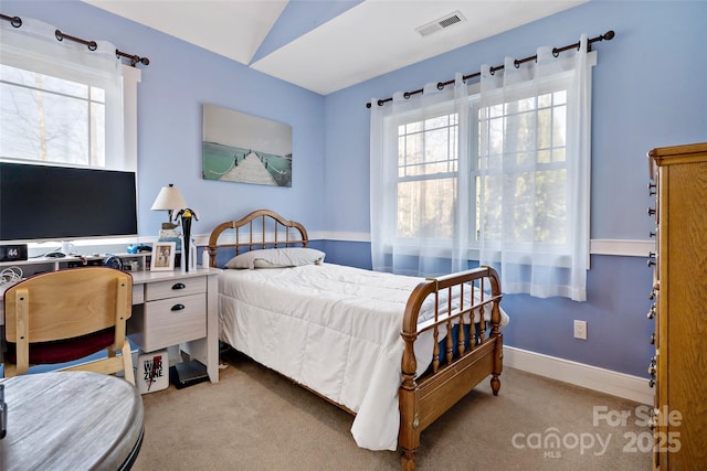 bedroom with vaulted ceiling, baseboards, visible vents, and light colored carpet