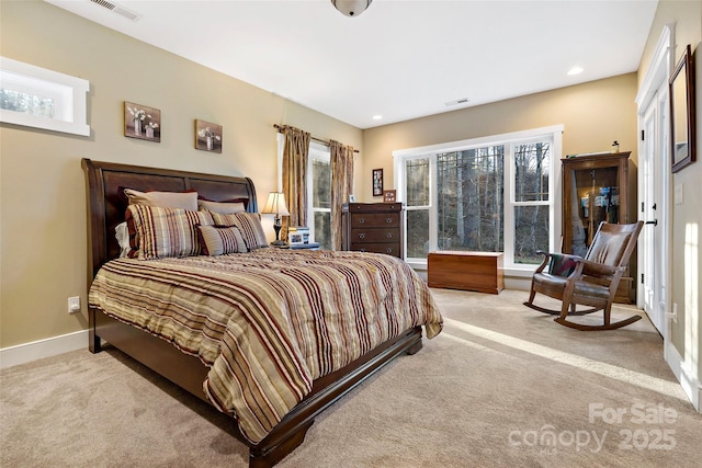 bedroom with light carpet, visible vents, and baseboards