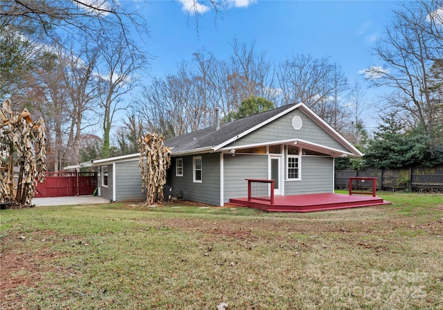 back of house featuring a lawn and a wooden deck