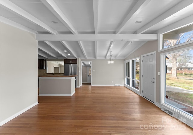 unfurnished living room with vaulted ceiling with beams and hardwood / wood-style flooring