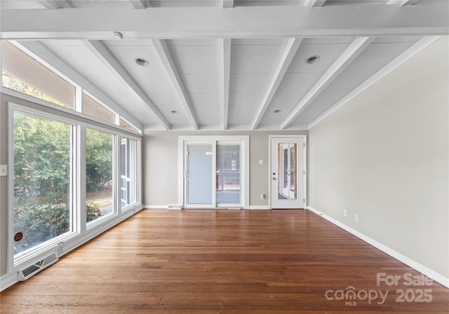 unfurnished room with hardwood / wood-style flooring, beamed ceiling, and plenty of natural light