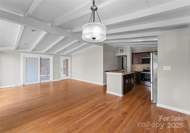 unfurnished living room featuring hardwood / wood-style floors and vaulted ceiling with beams