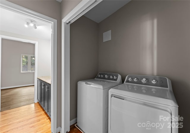 washroom with washing machine and dryer and light wood-type flooring