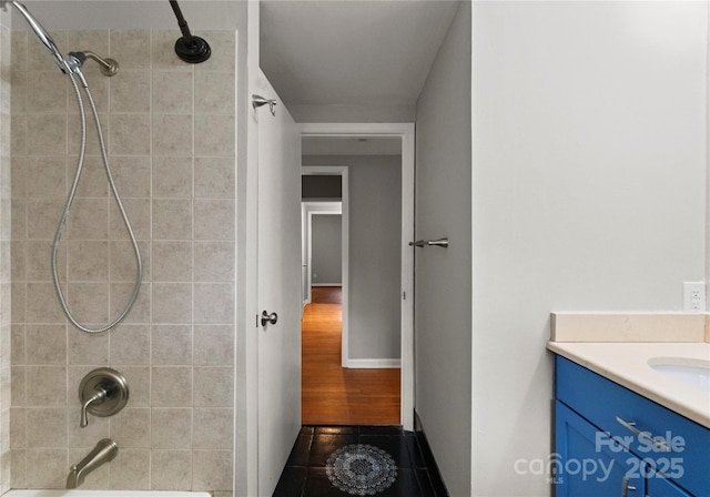 bathroom featuring vanity, tile patterned floors, and tiled shower / bath