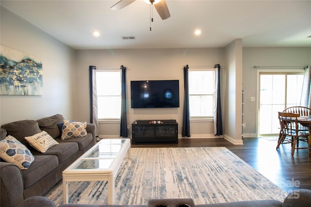 living room featuring ceiling fan and dark hardwood / wood-style floors