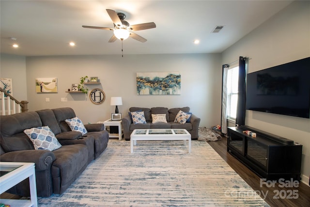 living room featuring ceiling fan and dark hardwood / wood-style flooring