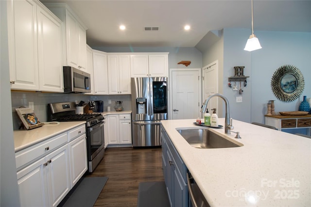 kitchen with white cabinets, decorative light fixtures, stainless steel appliances, and sink