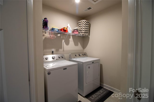 laundry room with light tile patterned floors and separate washer and dryer