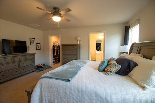 bedroom featuring carpet floors, ceiling fan, a spacious closet, connected bathroom, and a closet