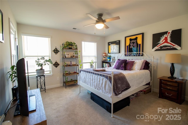 carpeted bedroom with multiple windows and ceiling fan