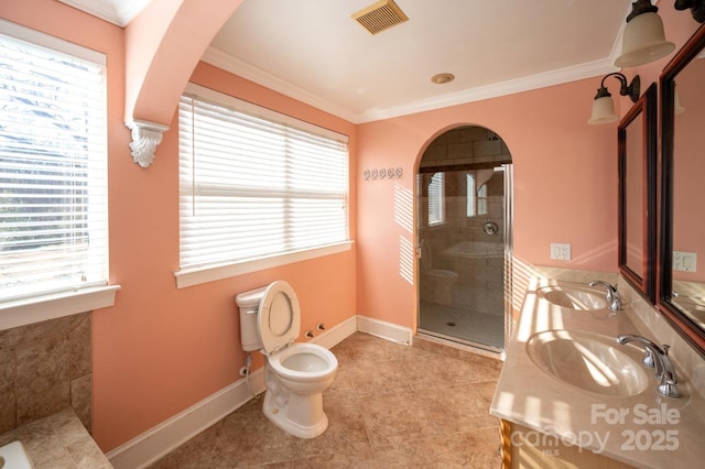 bathroom with crown molding, vanity, an enclosed shower, and toilet