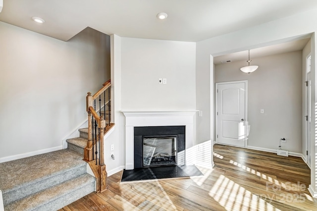 living room featuring a multi sided fireplace and hardwood / wood-style flooring