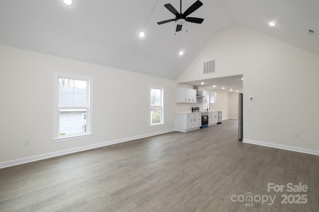 unfurnished living room featuring hardwood / wood-style floors, high vaulted ceiling, and ceiling fan