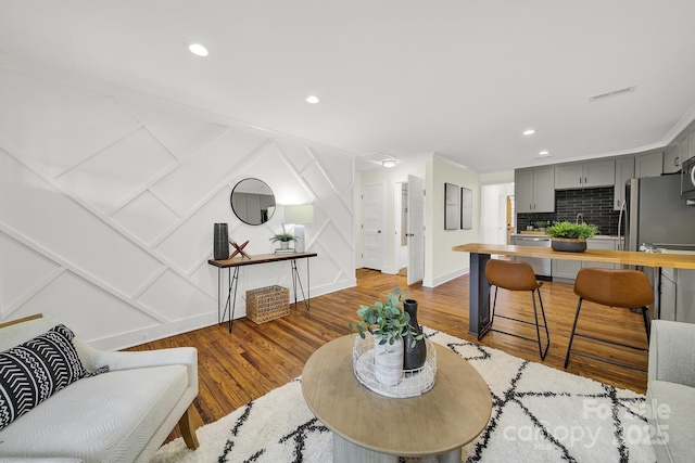 living room featuring hardwood / wood-style floors and crown molding