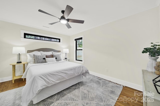 bedroom featuring wood-type flooring, ornamental molding, and ceiling fan