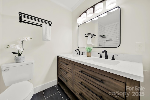 bathroom with tile patterned floors, vanity, toilet, and ornamental molding