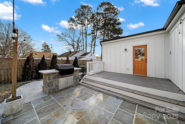 exterior space with a wooden deck, grilling area, and an outdoor kitchen