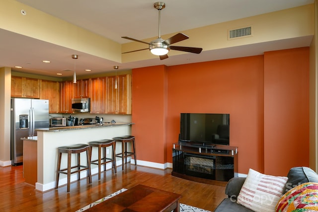 living room with wood-type flooring and ceiling fan