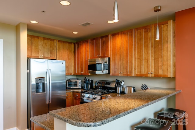 kitchen featuring stone counters, a kitchen breakfast bar, decorative light fixtures, kitchen peninsula, and stainless steel appliances